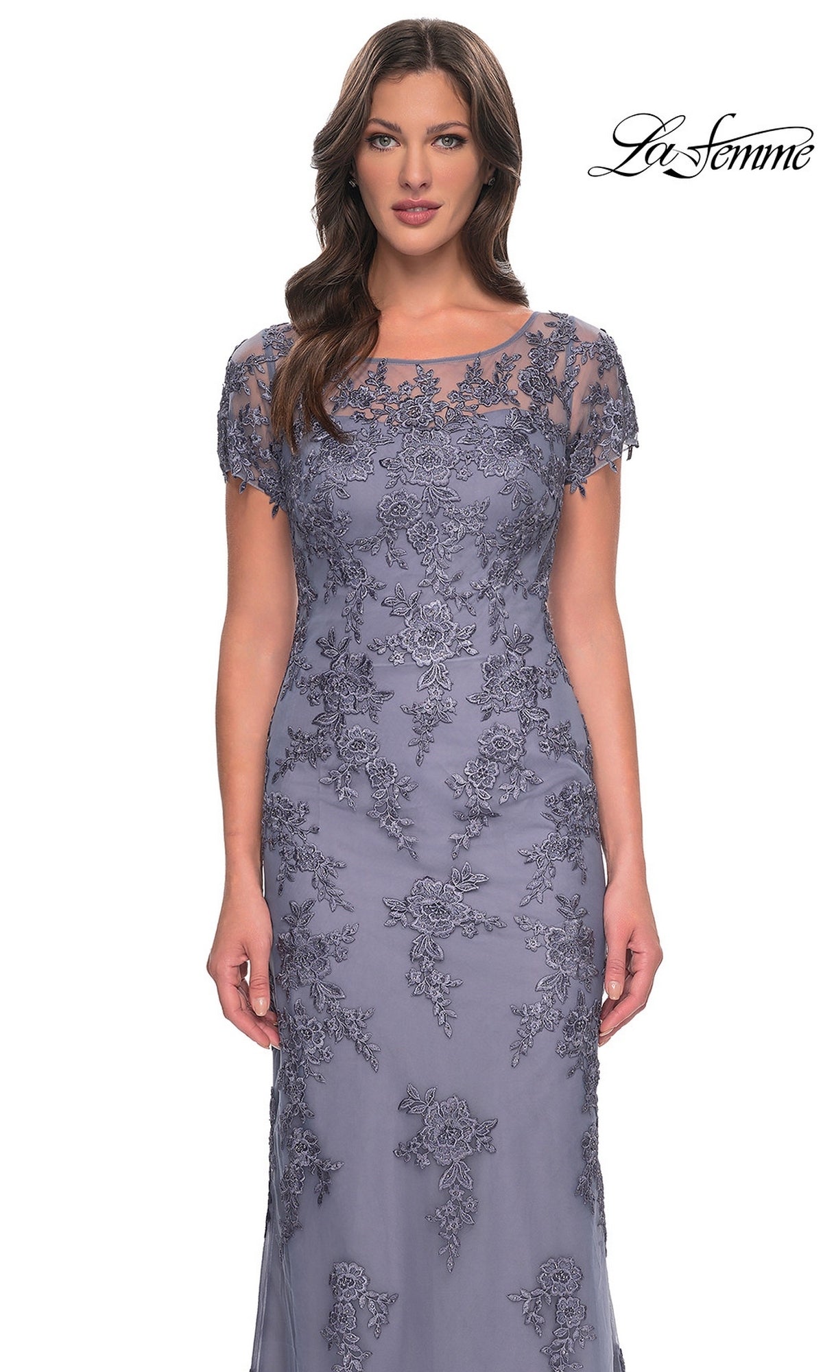 A woman wearing a slate gray, modest floor-length Long Formal Dress: La Femme 29792 featuring a sheer neckline, short sleeves, and floral embroidery.